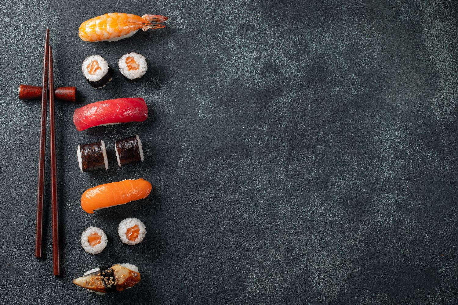 Ensemble de sushi et maki sur une table en pierre.
